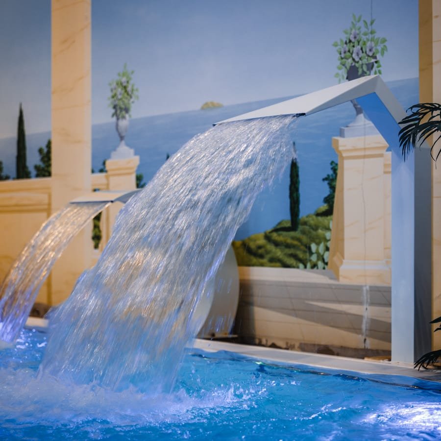 Schwalldusche ergießt sich ins blau beleuchtete Becken