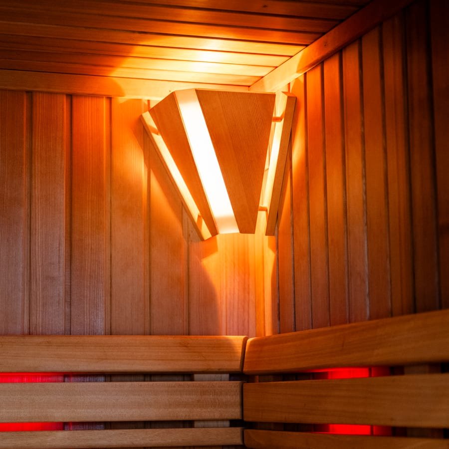 Warmes Licht in der finnischen Sauna mit Holzbänken